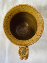 Load image into Gallery viewer, A Mug:  (Goldenrod Ceramic Mug on Speckled Clay with a Daisy Thumb Rest)