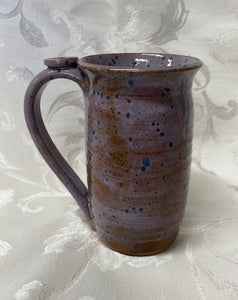 A Mug:  (Brown/Purple with Blue Spots and a Flower Thumb Rest)