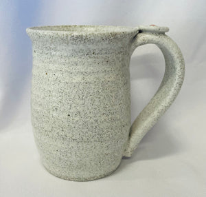 A Mug:  ( Small White Tea Mug on Speckled Clay with a Flower Thumb Rest)
