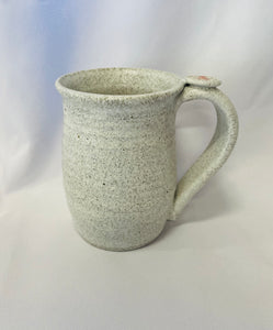 A Mug:  ( Small White Tea Mug on Speckled Clay with a Flower Thumb Rest)