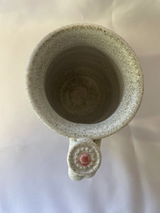 A Mug:  ( Small White Tea Mug on Speckled Clay with a Flower Thumb Rest)