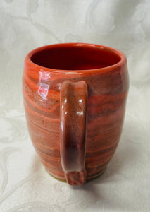 A Mug:  (Peach Colored Ceramic Mug on Tri-Colored Clay with a Turtle Stamp on the Handle Bottom))